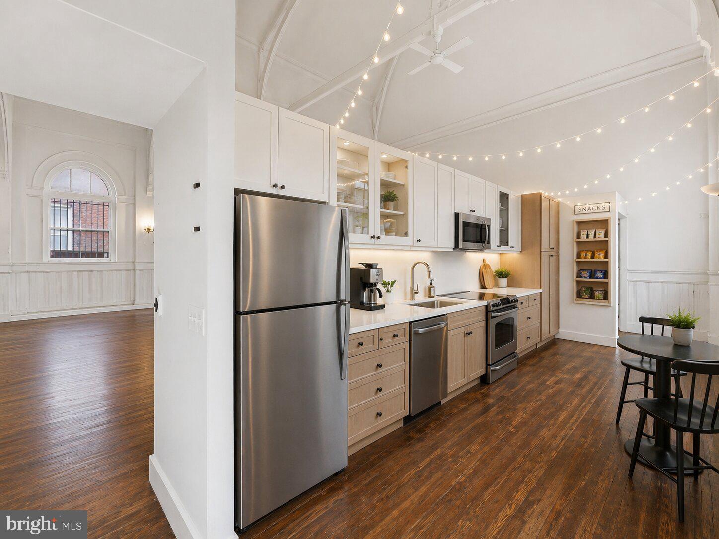 1401 Light Street Baltimore, MD 21230 - Photo 34 of 39 a kitchen with a refrigerator a stove top oven a sink dishwasher a dining table and chairs with wooden floor