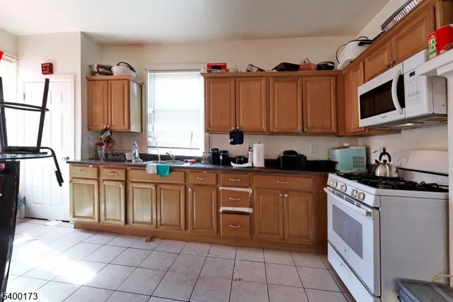 a kitchen with stainless steel appliances granite countertop a stove top oven a sink a microwave and cabinets