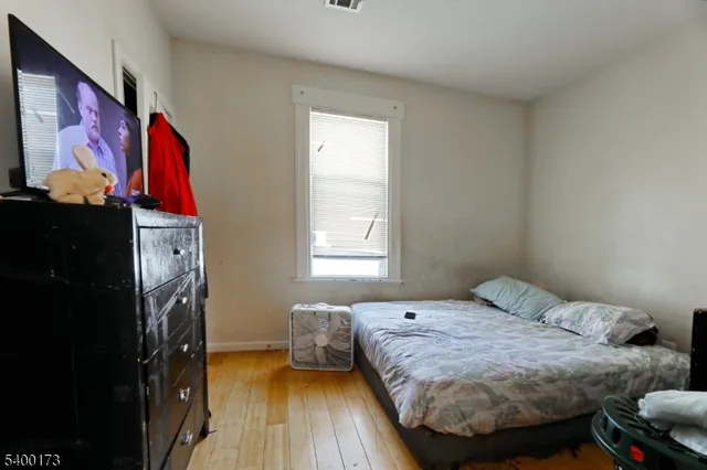 a bedroom with a bed and wooden floor