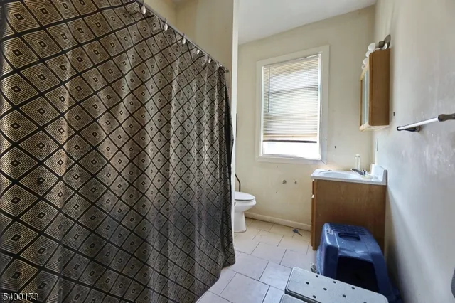 a bathroom with a sink toilet and window