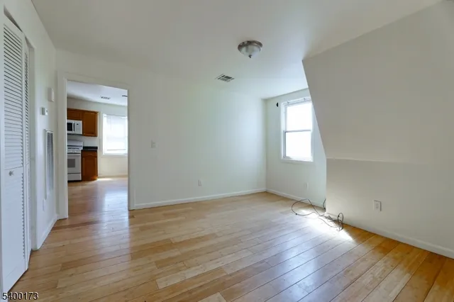 an empty room with wooden floor and a window