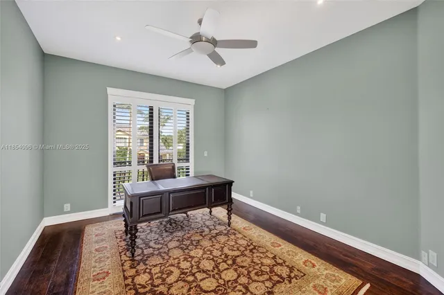 an empty room with wooden floor cabinet and windows