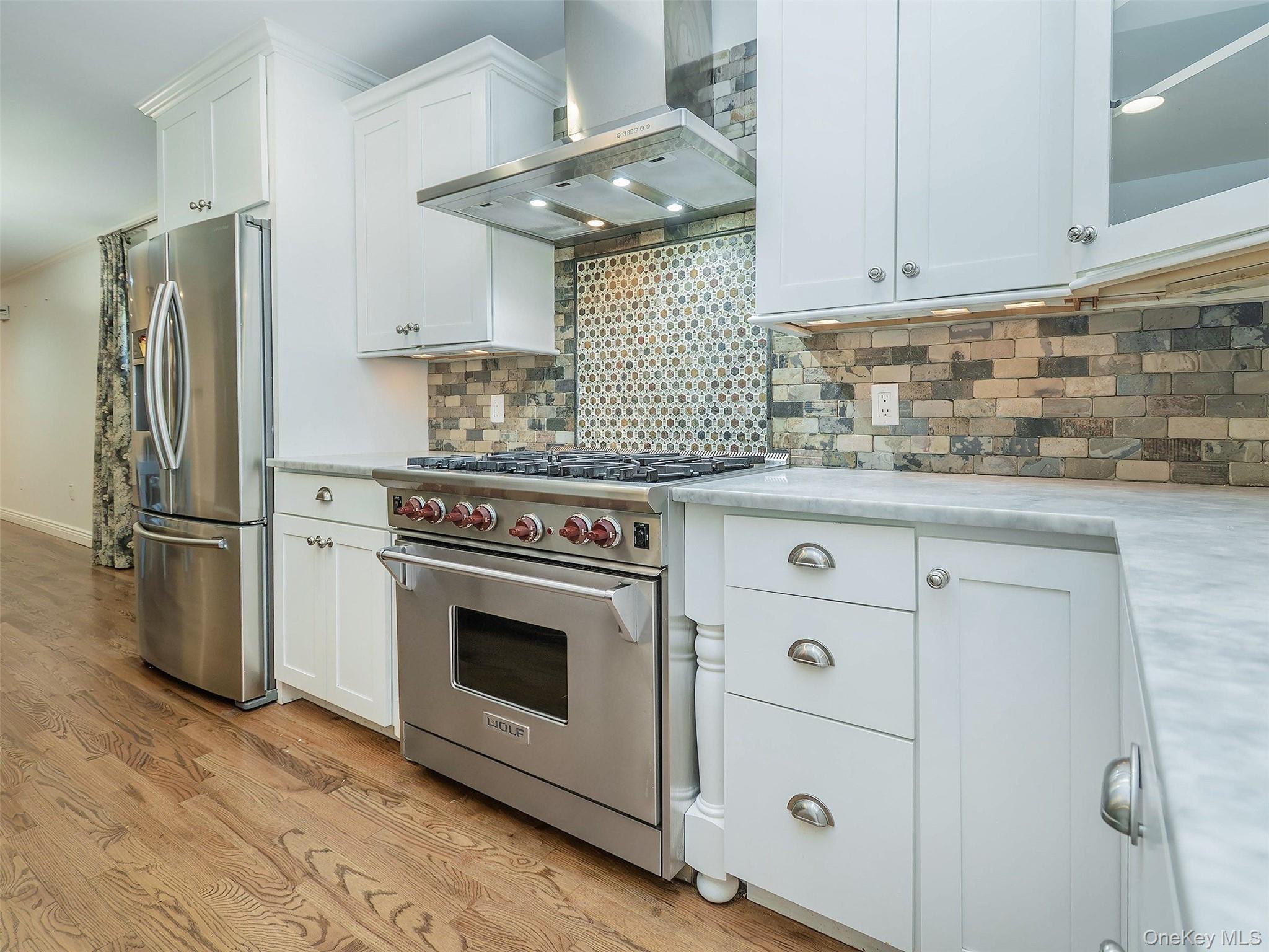 21 Marwood Road North Port Washington, NY 11050 - Photo 10 of 35 a kitchen with cabinets stainless steel appliances and wooden floor