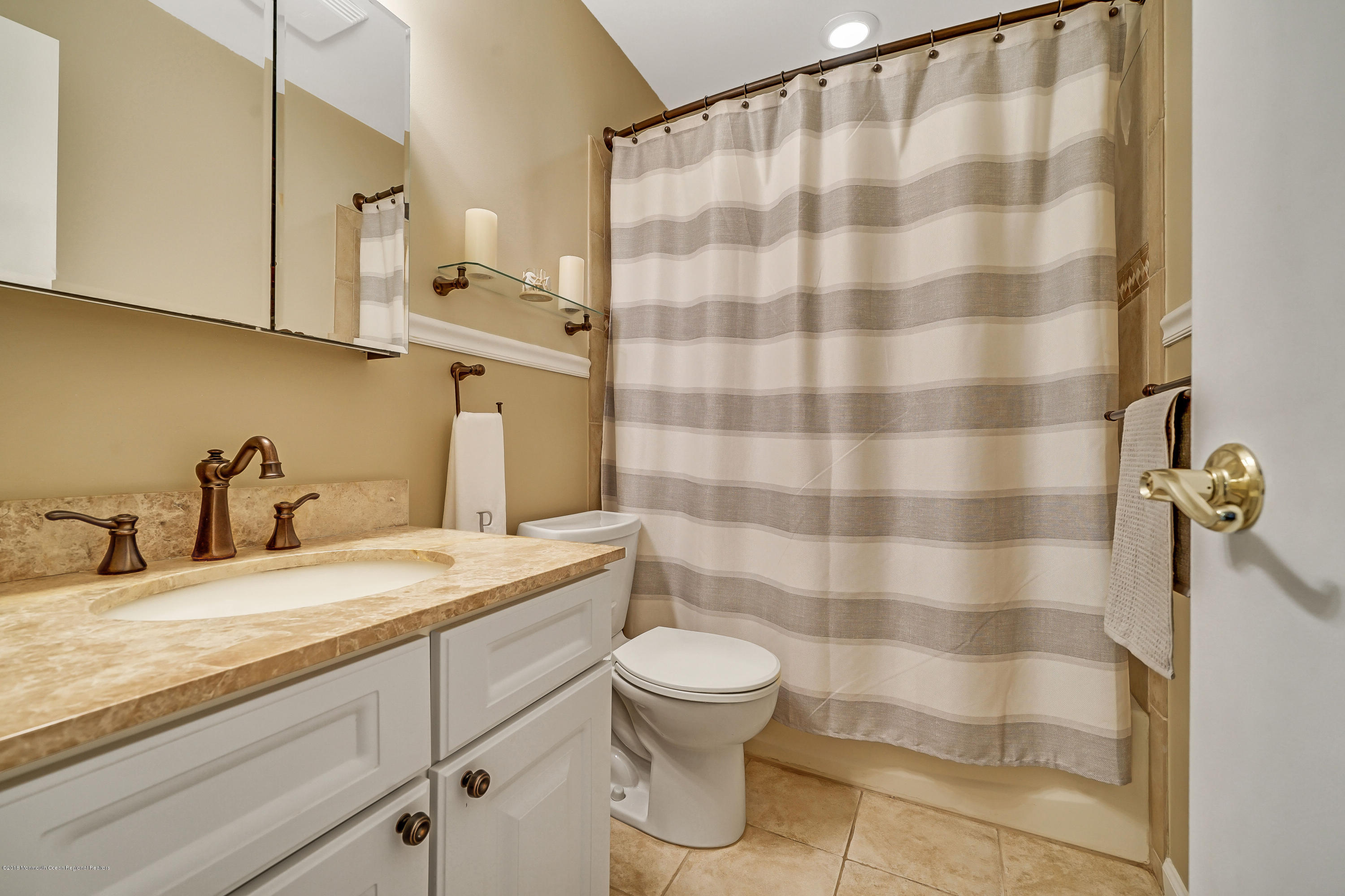 118 Greenwood Loop Road Brick, NJ 08724 - Photo 15 of 18 a bathroom with a sink a toilet a mirror and shower curtain