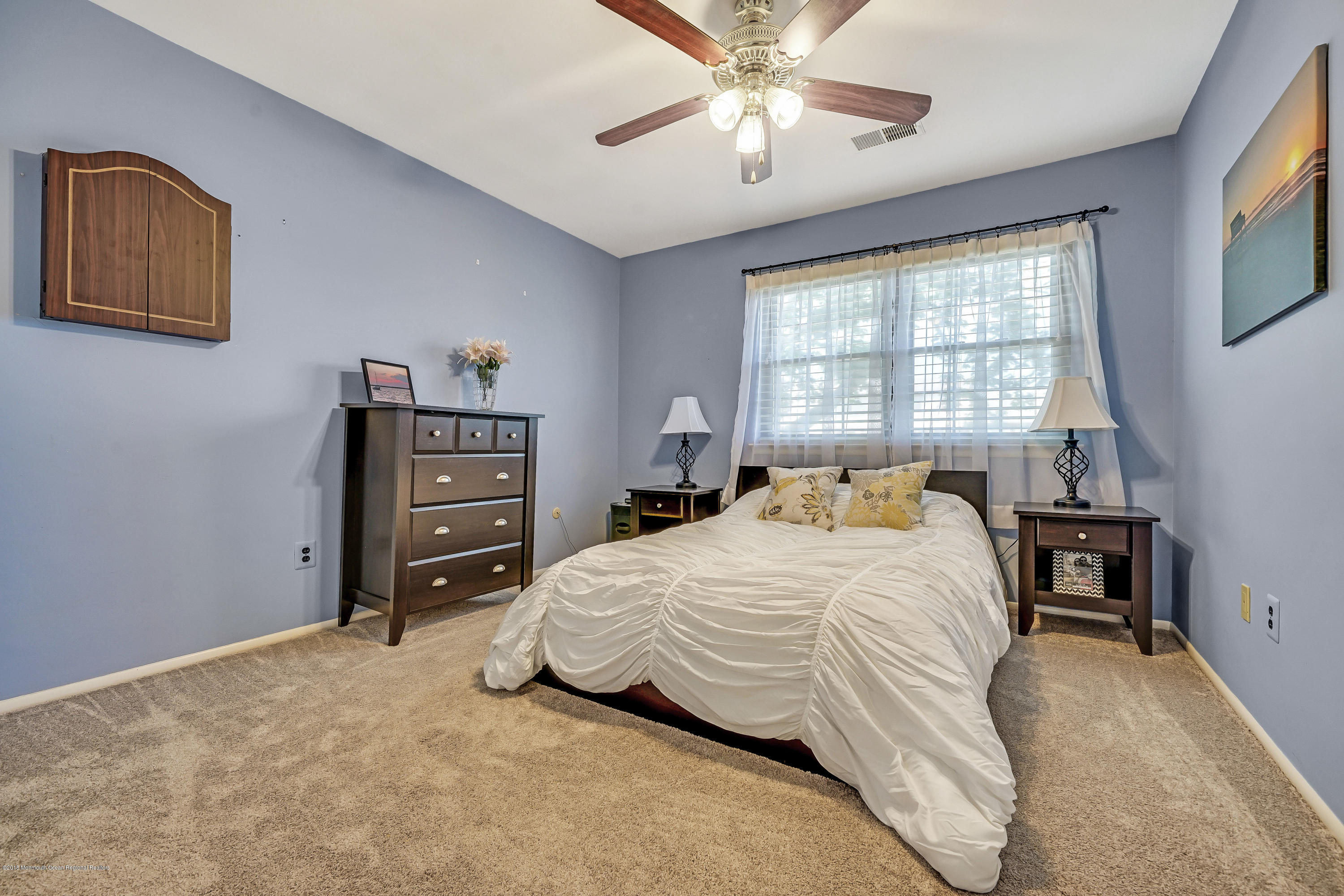 118 Greenwood Loop Road Brick, NJ 08724 - Photo 16 of 18 a bedroom with a bed and a chandelier