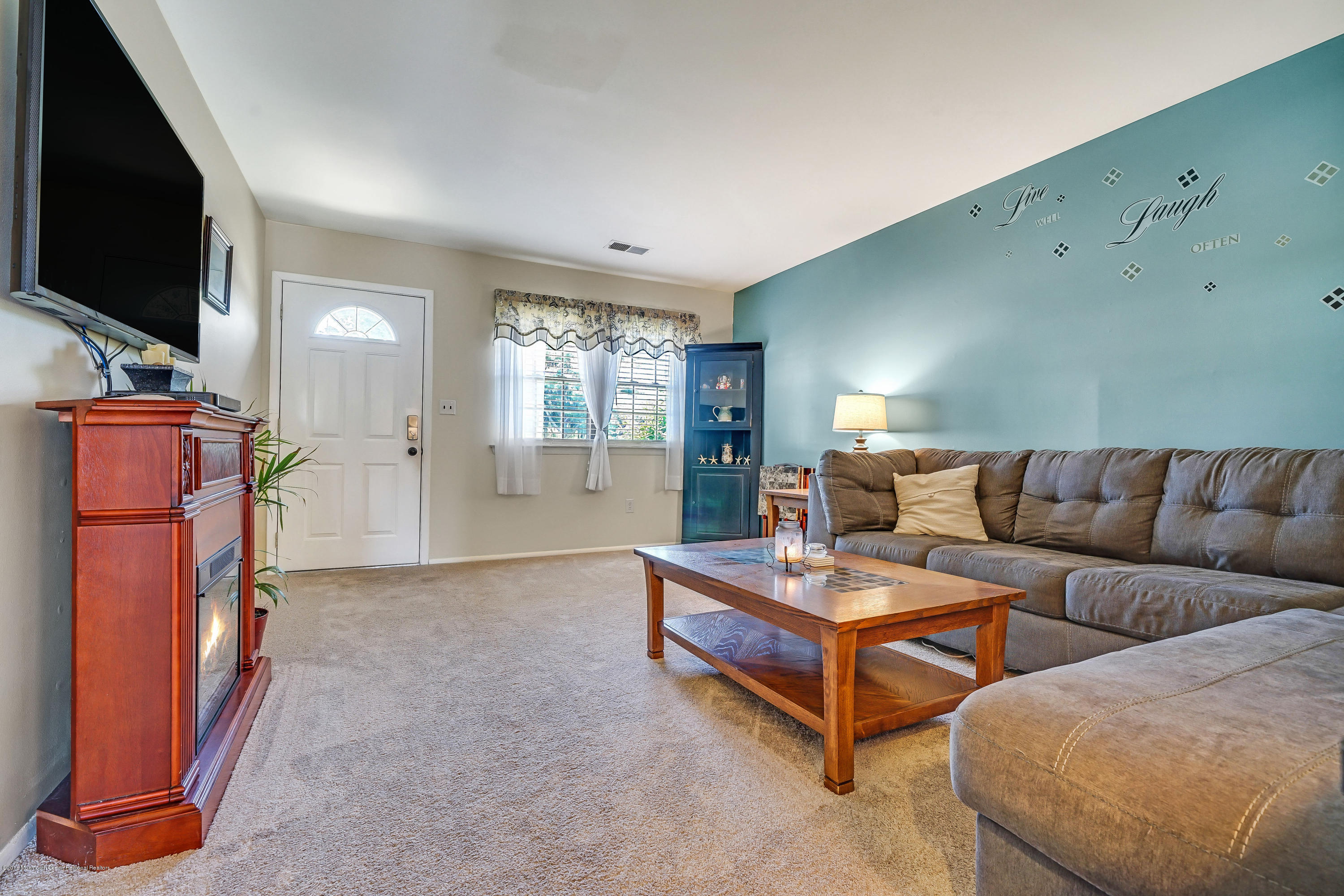 118 Greenwood Loop Road Brick, NJ 08724 - Photo 6 of 18 a living room with furniture a flat screen tv and a fireplace