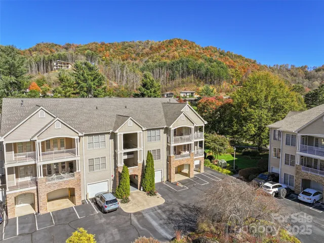 a view of a big house with a big yard and large trees