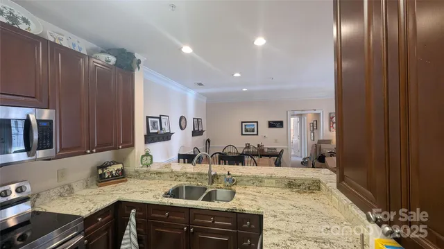 a view of a kitchen counter space a sink wooden floor and living room view