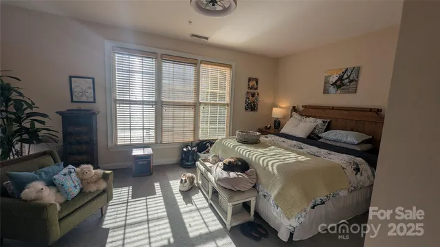 a bedroom with bed couch and window