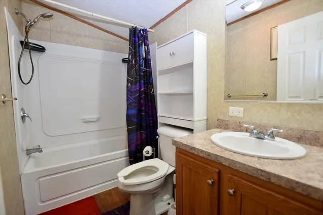 a bathroom with a granite countertop sink toilet and shower