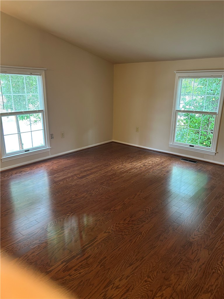 110 North Broad Street Pendleton, SC 29670 - Photo 22 of 32 Natural light streams into this room, illuminating rich hardwood flooring and a vaulted ceiling.