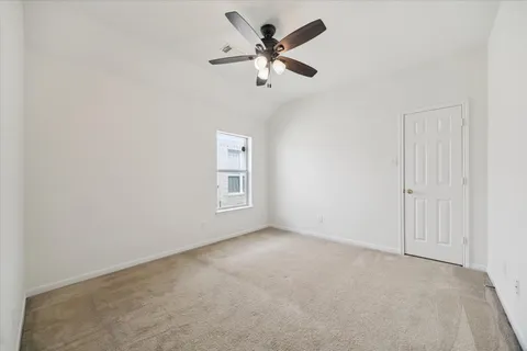 an empty room with windows and fan