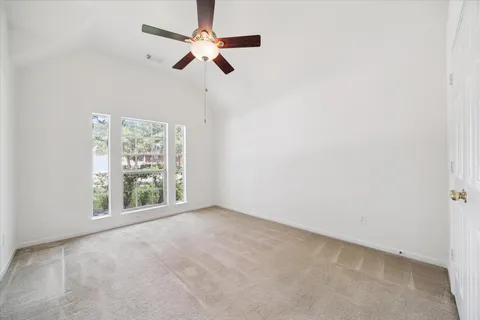 an empty room with a window and a fan