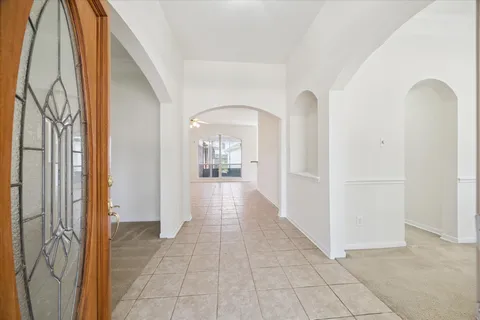 a view of a hallway with wooden floor and a living room
