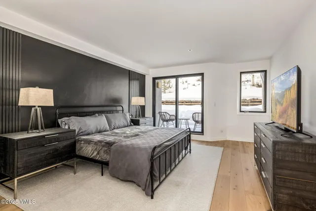 a bedroom with a bed and a flat tv screen on dresser