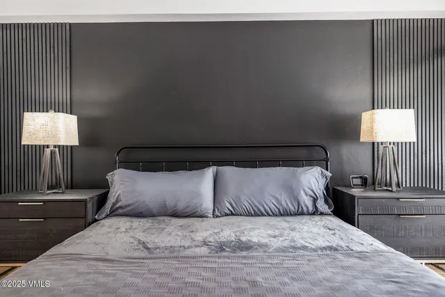 a large bed sitting in a bedroom next to a lamp