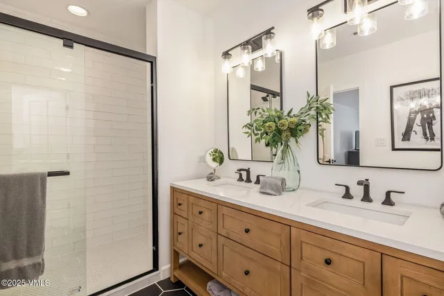 a bathroom with a double vanity sink mirror and shower