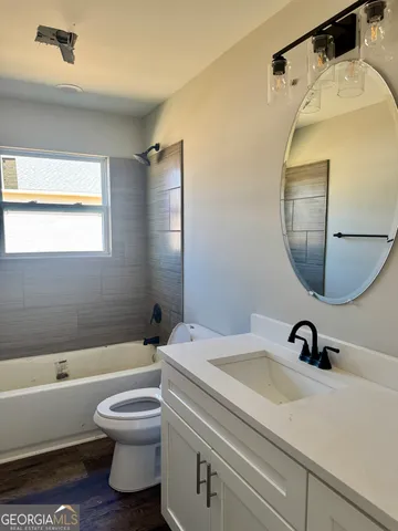 a bathroom with a sink a toilet and a mirror