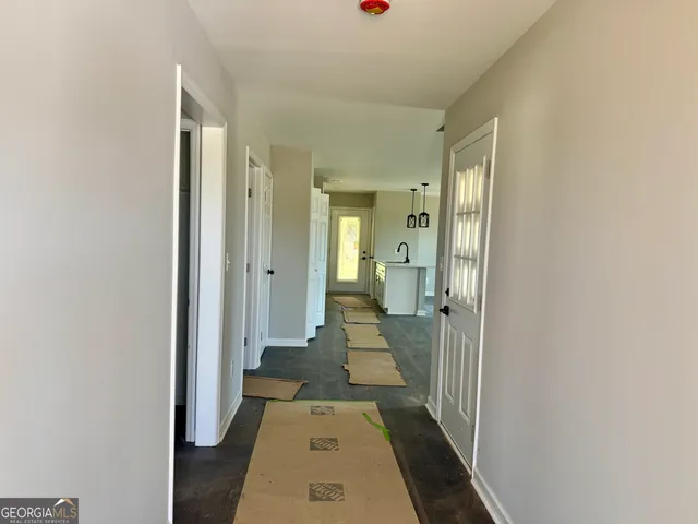 a view of a hallway with a livingroom and a bathroom with sink