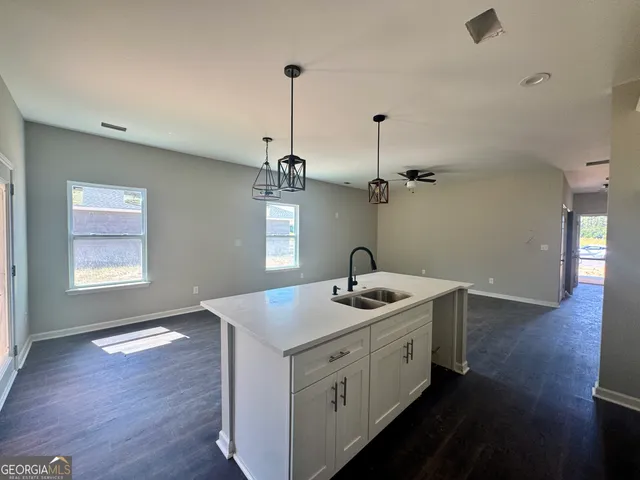 a view of a kitchen sink and wooden floor