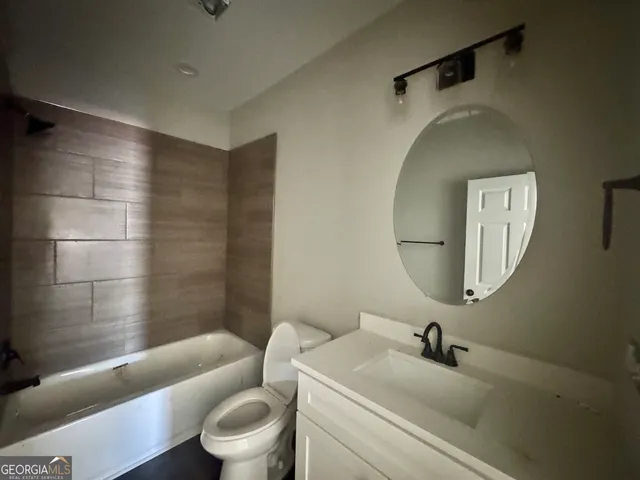 a bathroom with a toilet a sink and a mirror