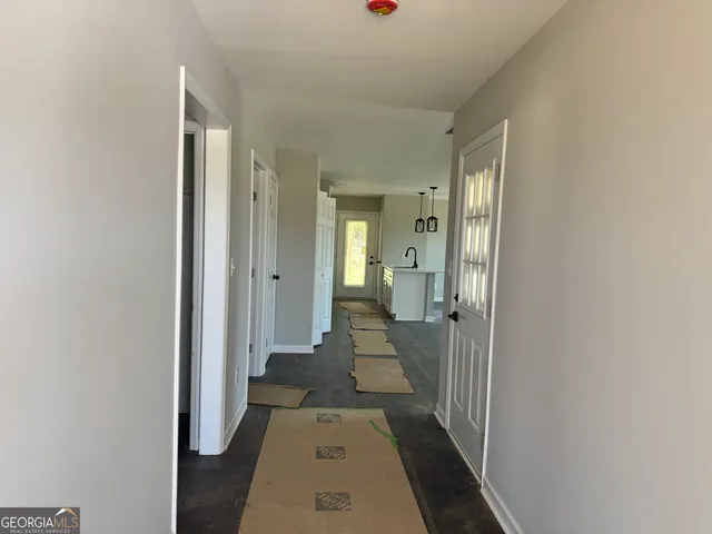 a view of a hallway with a livingroom and a bathroom with sink