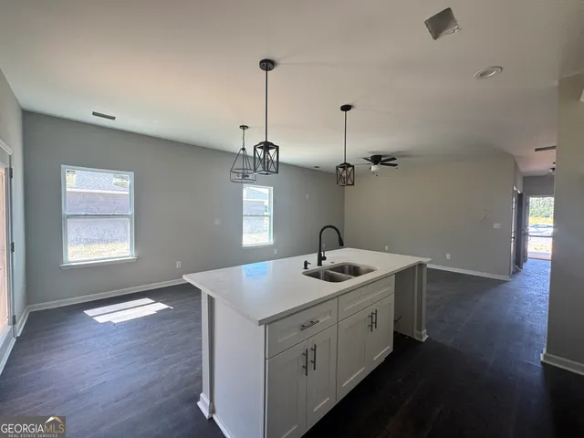 a view of a kitchen sink and wooden floor