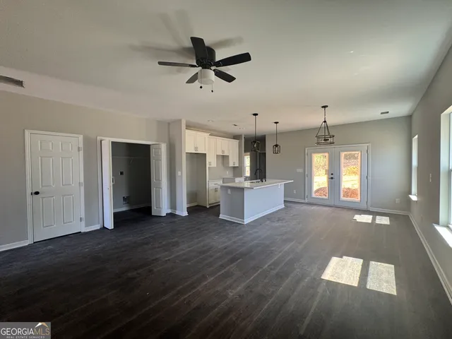 a view of a kitchen with wooden floor and a ceiling fan