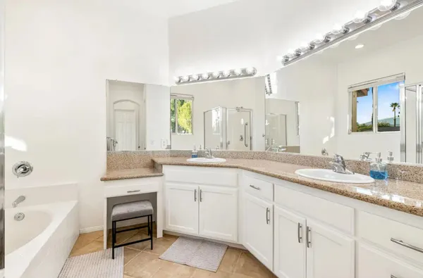a bathroom with a granite countertop sink mirror and a bathtub
