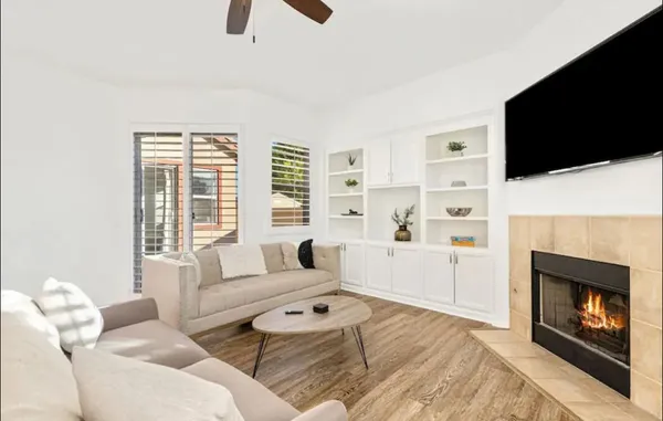 a living room with furniture a flat screen tv and a fireplace