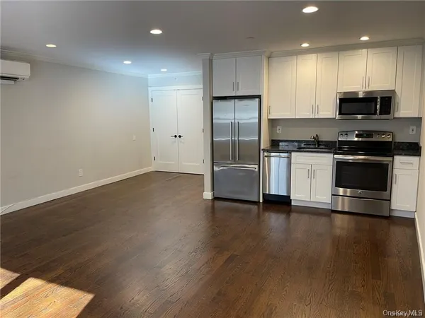 a kitchen with stainless steel appliances granite countertop a stove a refrigerator and a microwave