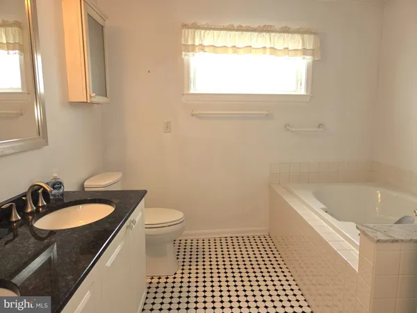 a bathroom with a sink a window and a toilet