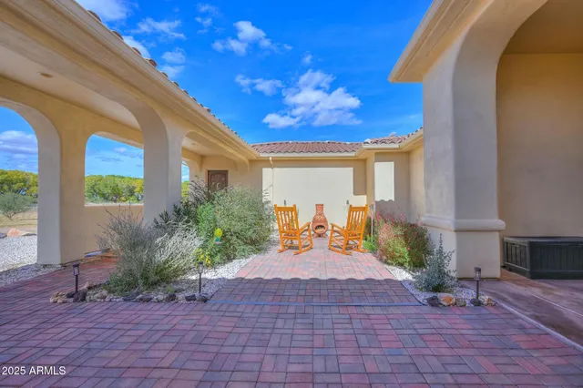 a view of a porch with chairs and potted plants