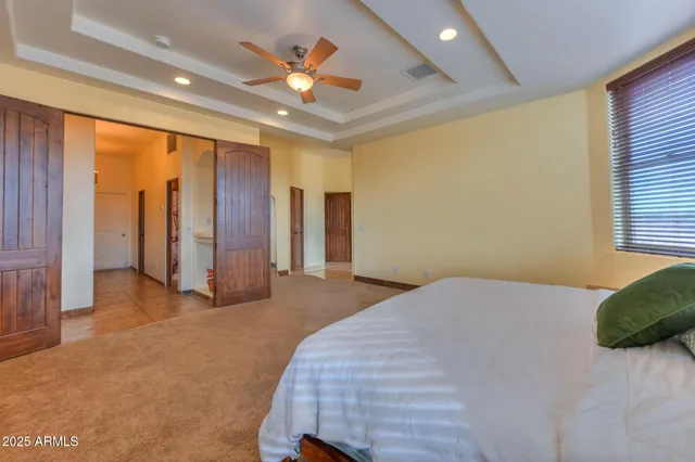 a bedroom with a large bed and a chandelier