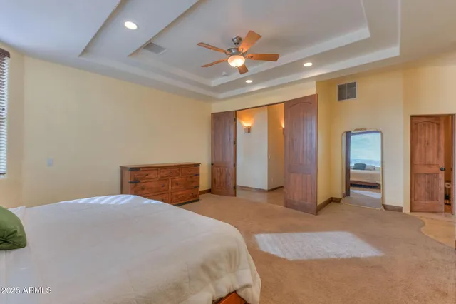 a bedroom with a large bed and a ceiling fan