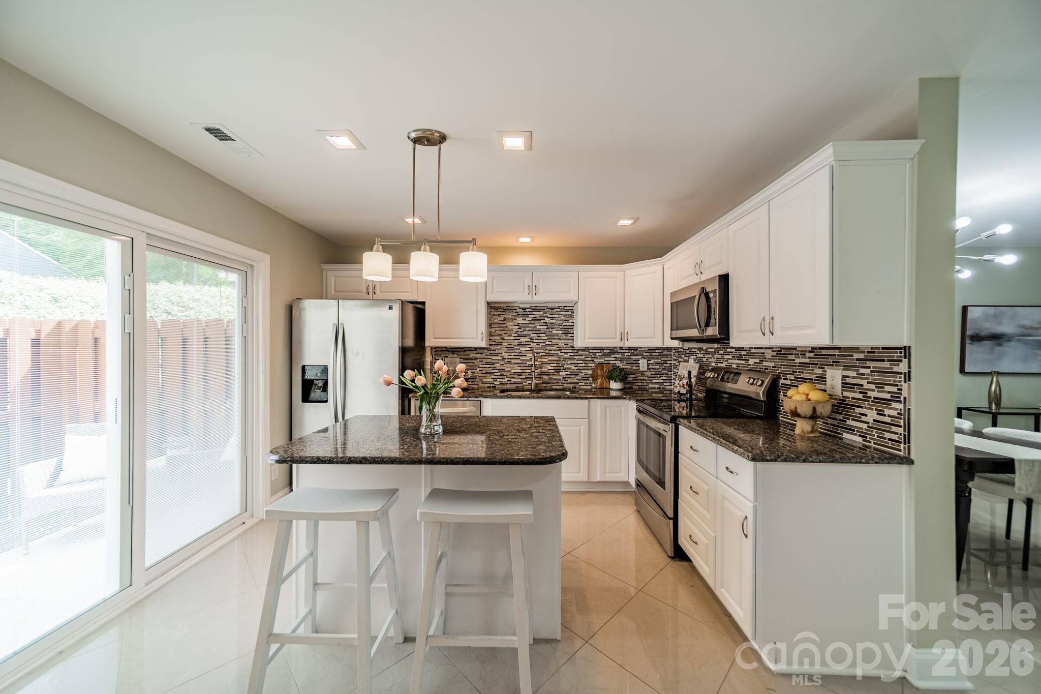 9226 Four Mile Creek Road Charlotte, NC 28277 - Photo 16 of 39 a kitchen with stainless steel appliances kitchen island granite countertop a stove a sink and a refrigerator