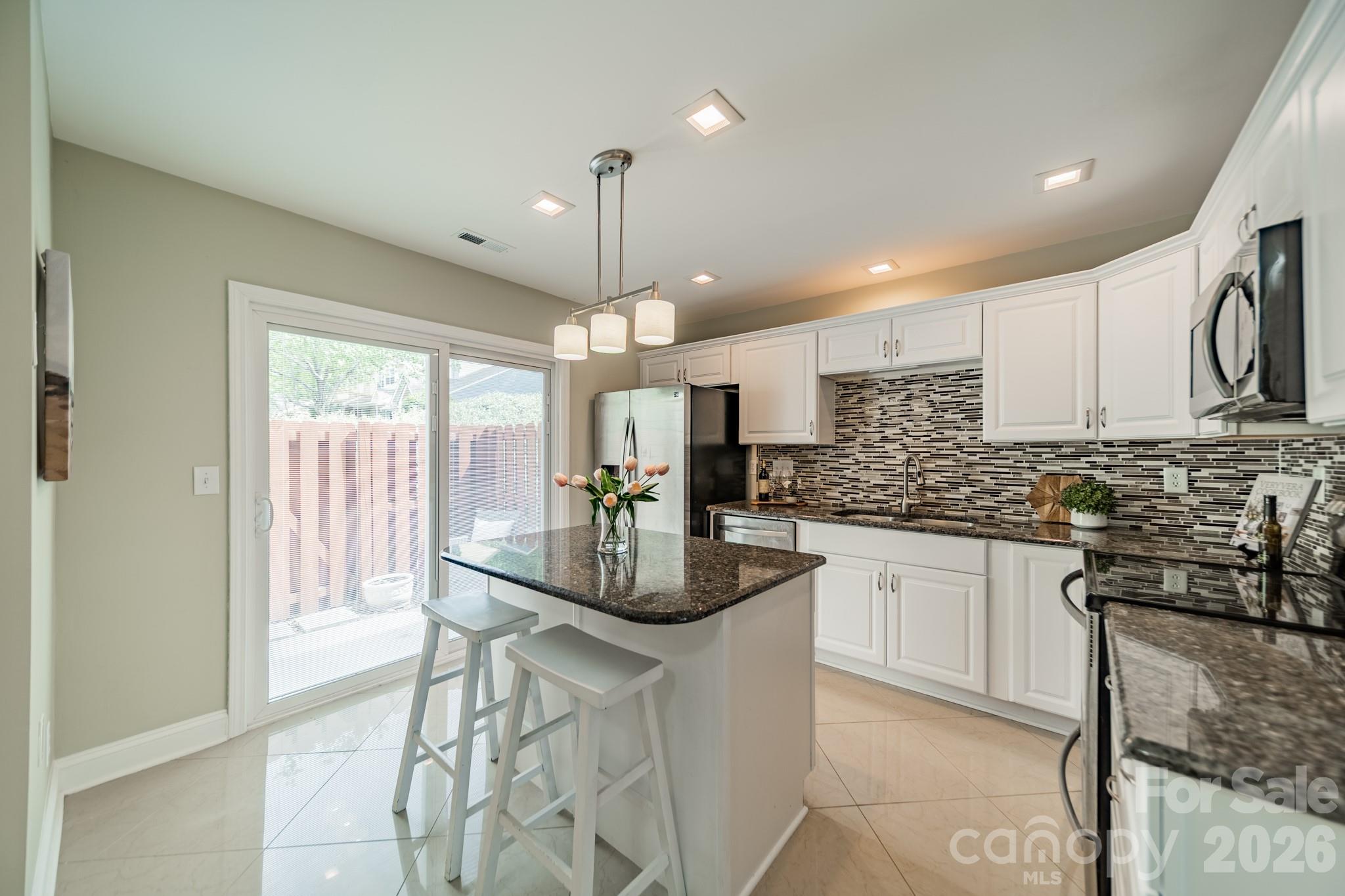 9226 Four Mile Creek Road Charlotte, NC 28277 - Photo 17 of 39 a kitchen with stainless steel appliances kitchen island granite countertop a sink and cabinets