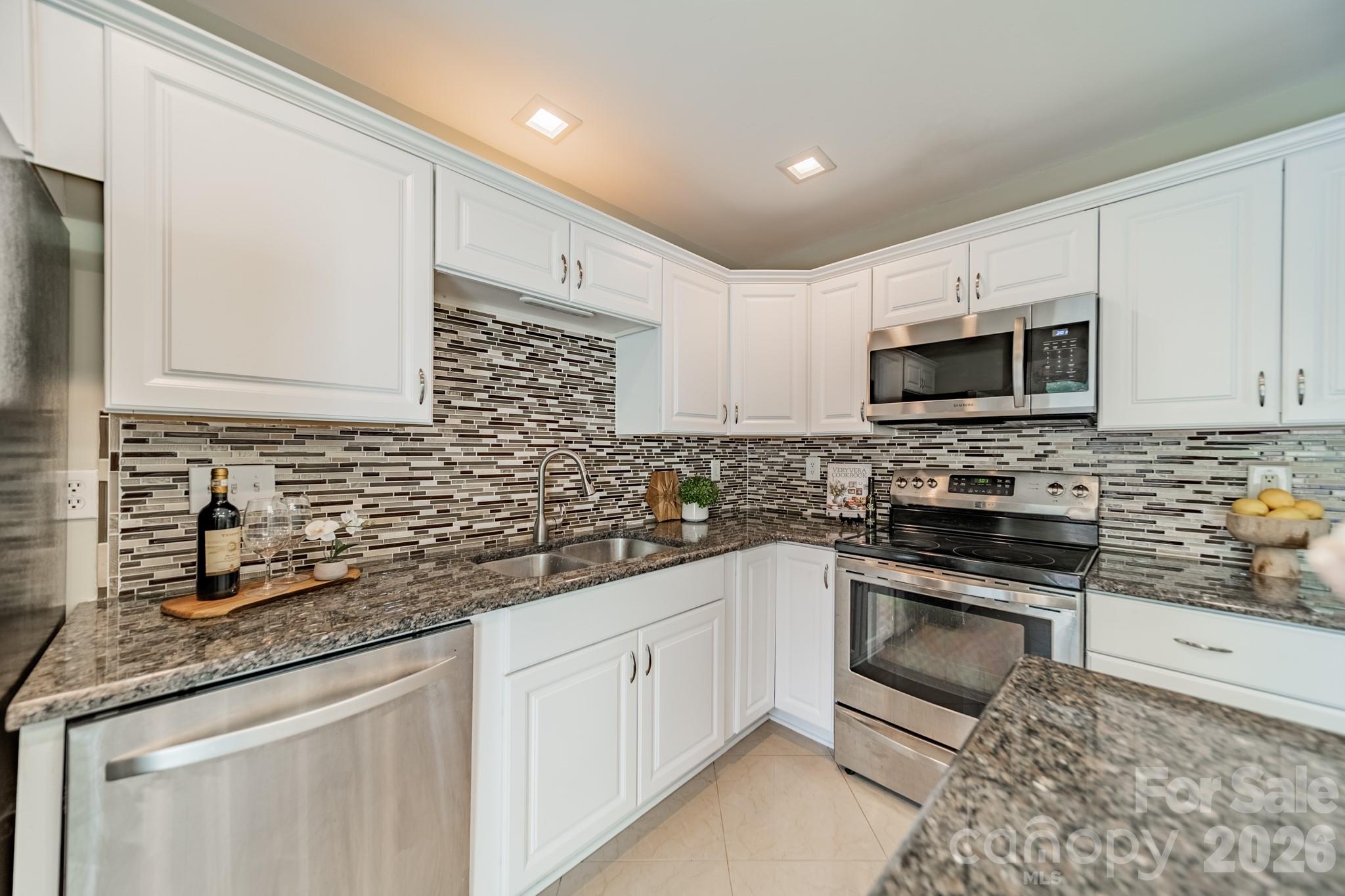 9226 Four Mile Creek Road Charlotte, NC 28277 - Photo 18 of 39 a kitchen with stainless steel appliances granite countertop a sink a stove a microwave and cabinets