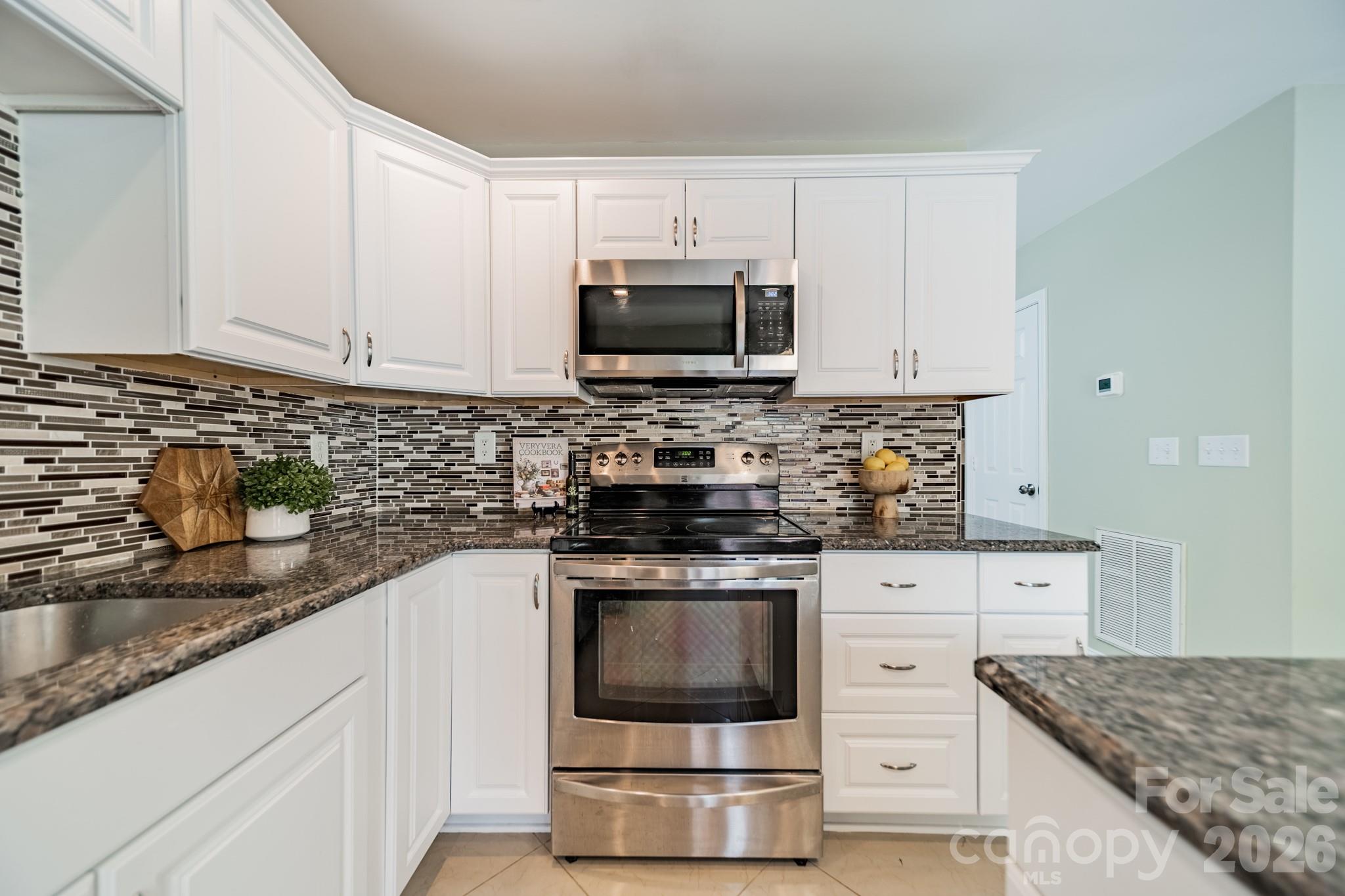 9226 Four Mile Creek Road Charlotte, NC 28277 - Photo 21 of 39 a kitchen with stainless steel appliances granite countertop a stove a sink and a microwave