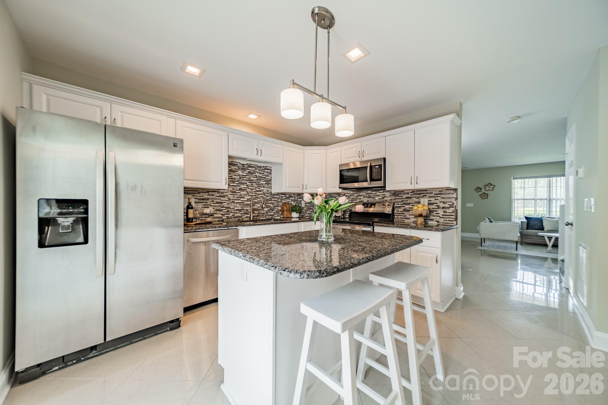 9226 Four Mile Creek Road Charlotte, NC 28277 - Photo 22 of 39 a kitchen with stainless steel appliances granite countertop a refrigerator a sink dishwasher a stove and white cabinets with wooden floor