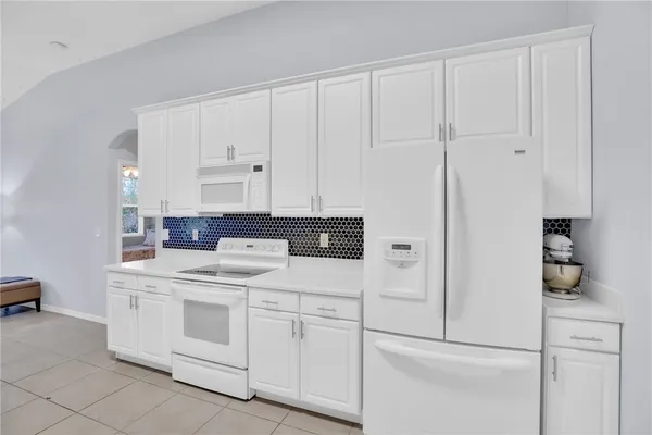 a kitchen with white cabinets and white appliances