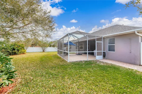 a view of a house with a large tree and a yard