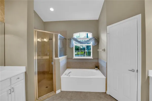 a bathroom with a bathtub a shower a sink and a mirror