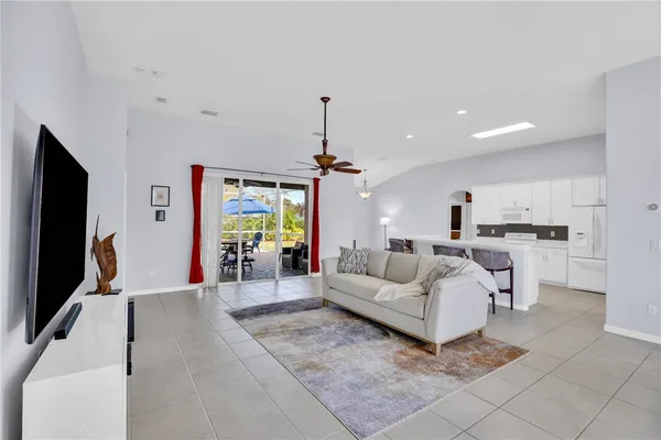a living room with furniture a chandelier and a flat screen tv