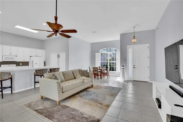 a living room with furniture and a view of kitchen