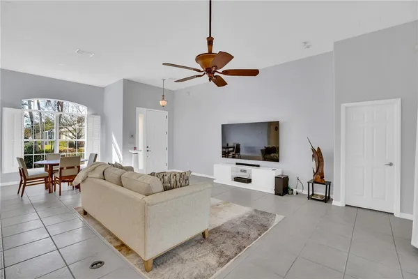 a living room with furniture a flat screen tv and a window