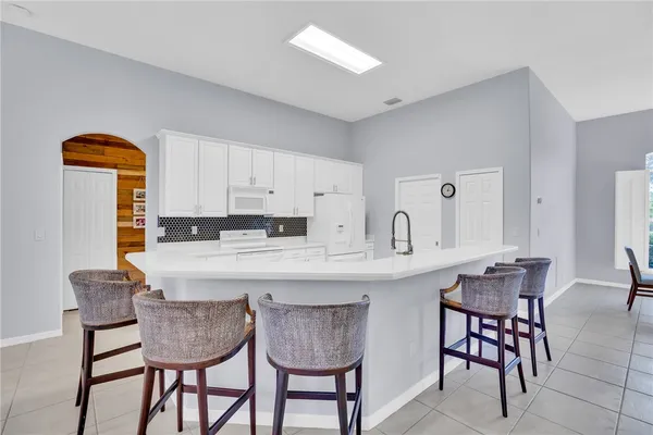a kitchen with stainless steel appliances granite countertop a table and chairs