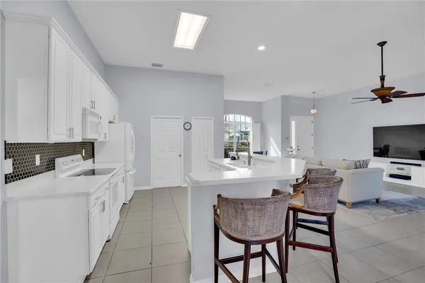 a kitchen with a dining table chairs and white cabinets