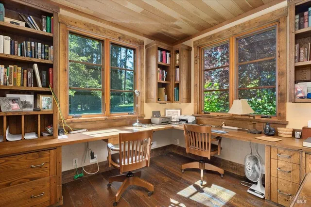 a view of a workspace with furniture and a window
