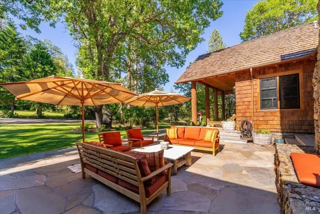 an outdoor sitting area with furniture and umbrella